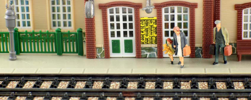 Das Bild zeigt zwei Menschen vor Gleisen einer Modelleisenbahn.